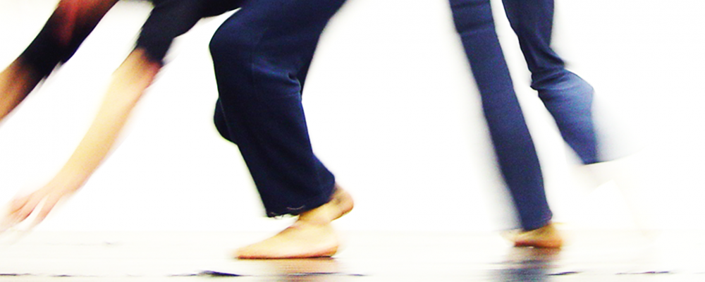 zwei tanzende Menschen, verwischtes Bild, vor allem die Füße und Beine sind zu sehen